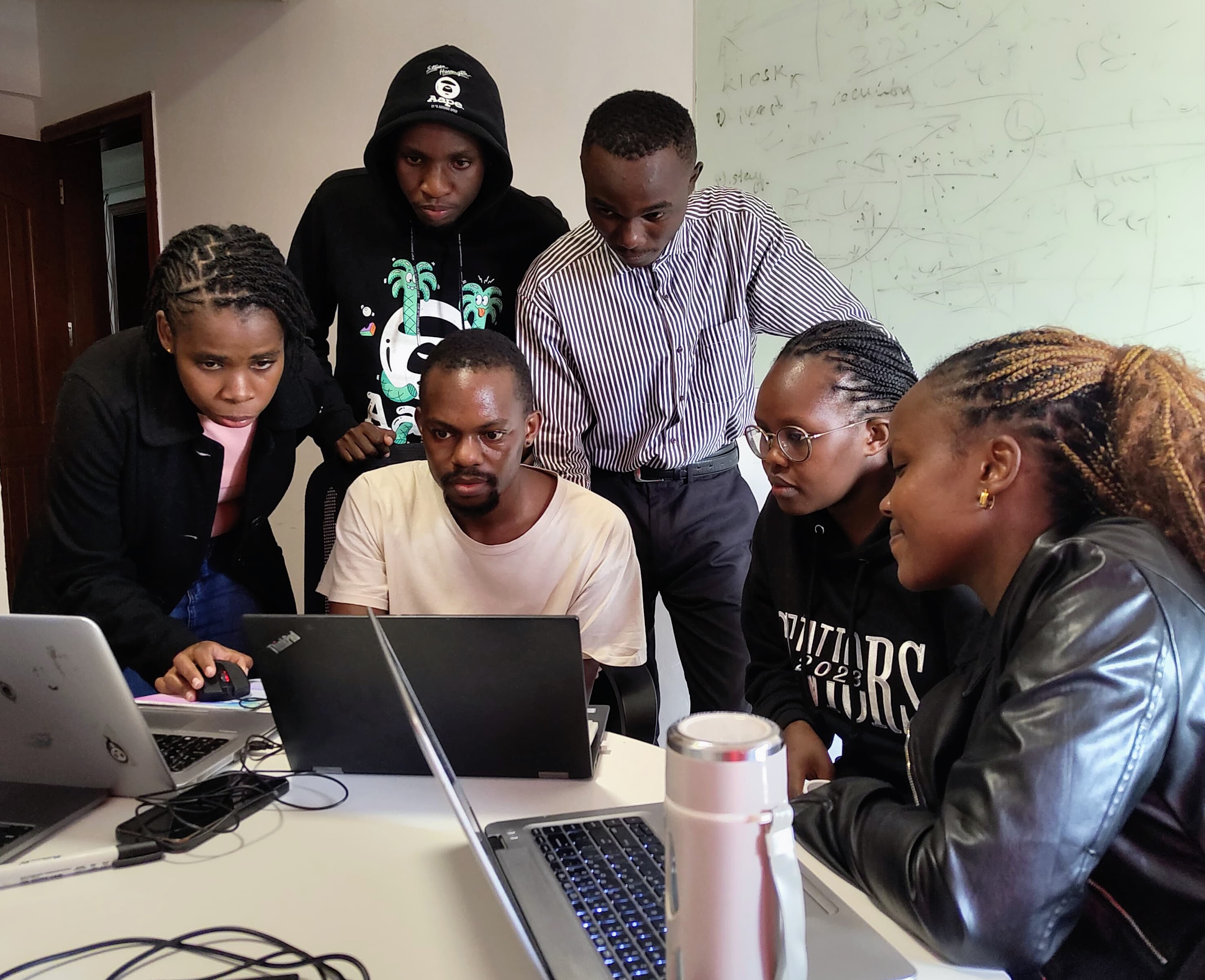 Apprentices in a planning session at a whiteboard